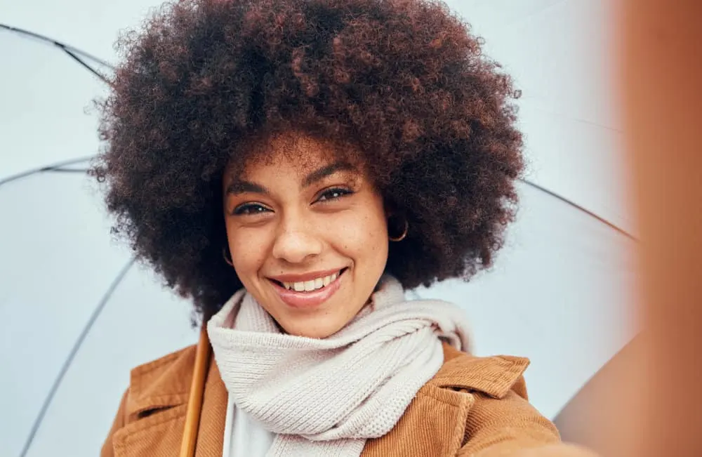 How to Use Flaxseed Gel for Curly Hair: DIY Hair Gel for Curls 5 A cute black female wearing a black and brown balayage afro styled with aloe vera juice.