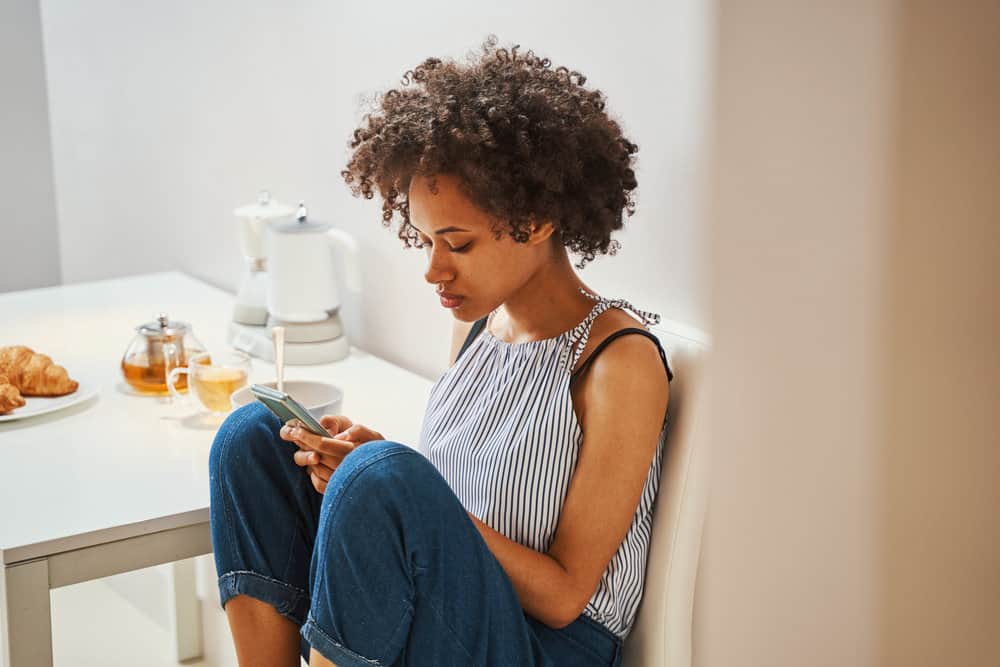 A lady is reading about various organic cleansing conditioners and hair care methods.