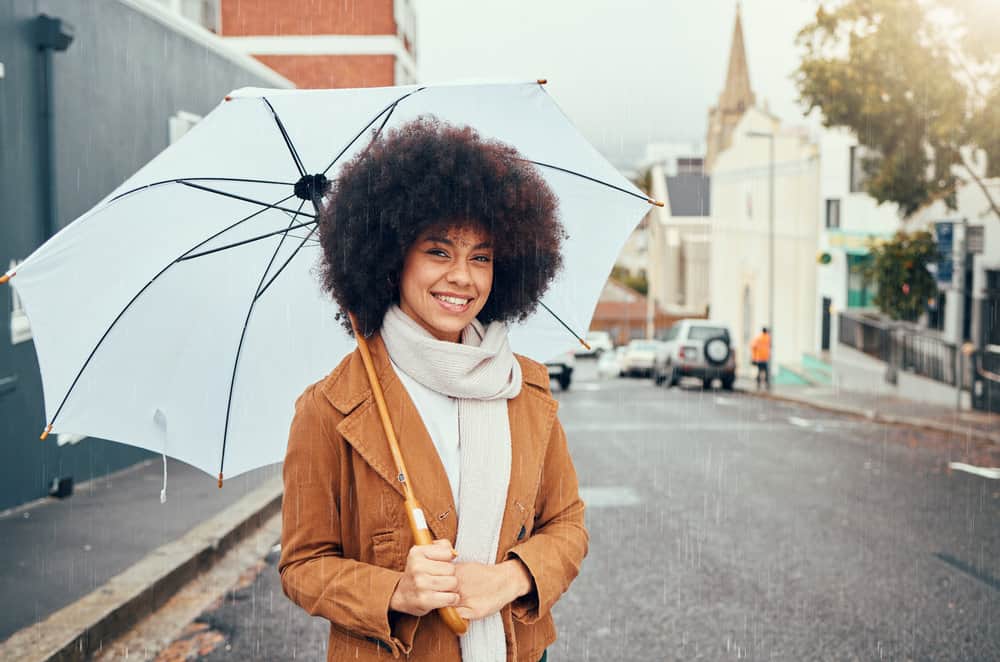 A fashionable young lady wearing bouncy curls styled with a flaxseed gel recipe and essential oil.