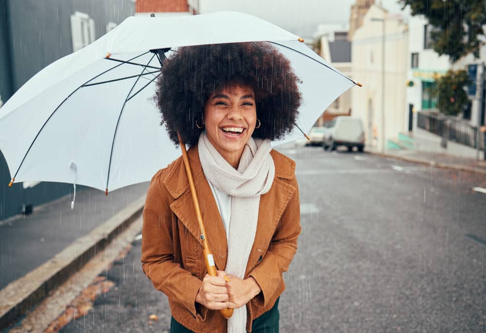 A black woman outside on a rainy day showed off her beautiful hair growth with a wash-n-go hairstyle.