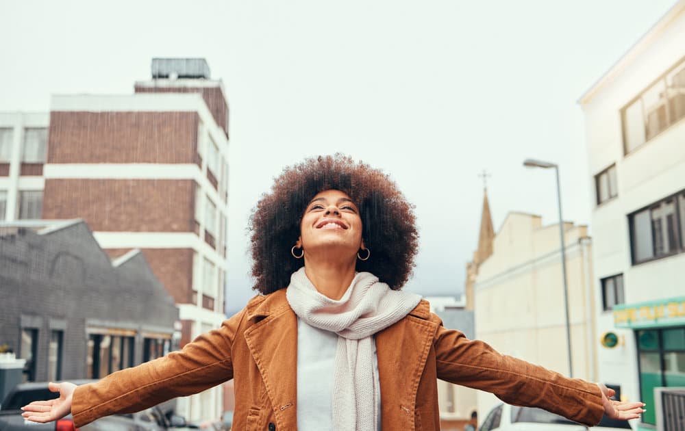 A black woman that uses an organic, all-natural curly hair routine wearing a bouncy afro hairstyle.