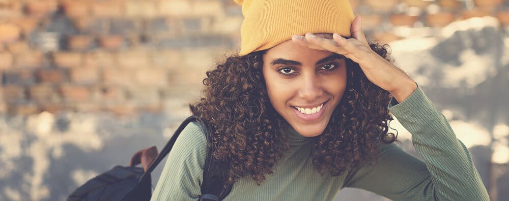 A cute black lady with healthy hair used a detangling brush to remove single-strand knots.