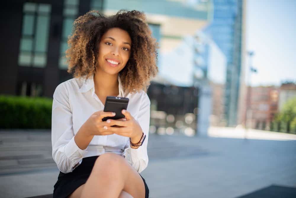 An African American female wearing a black and brown wash-and-go style styled with coconut hair oil.