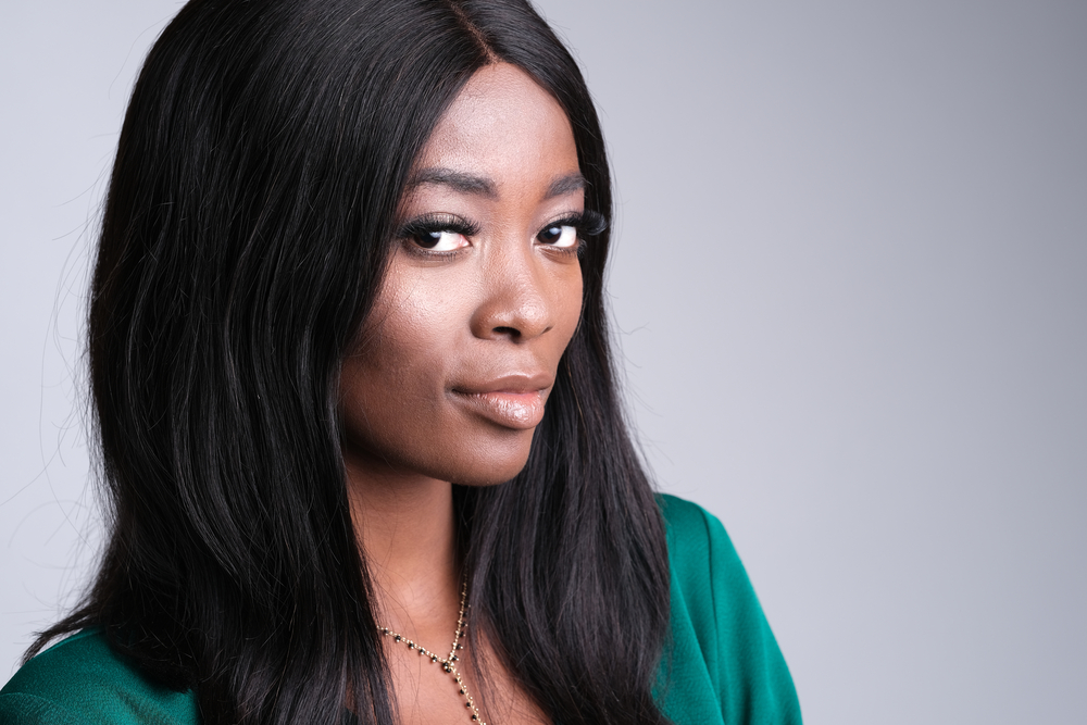 A beautiful black girl with a great smile wearing a human hair wig that came in a satin sealable bag.