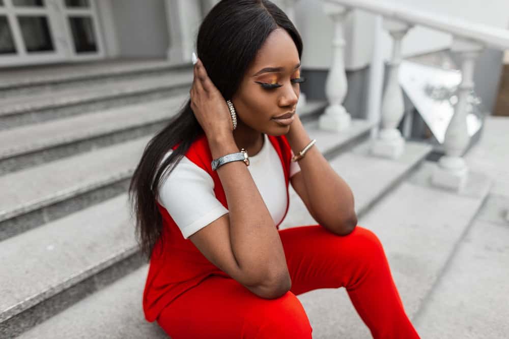 A charming woman with ginger brown hair and beautiful facial features wearing an HD lace front wig with a deep parting in the middle.