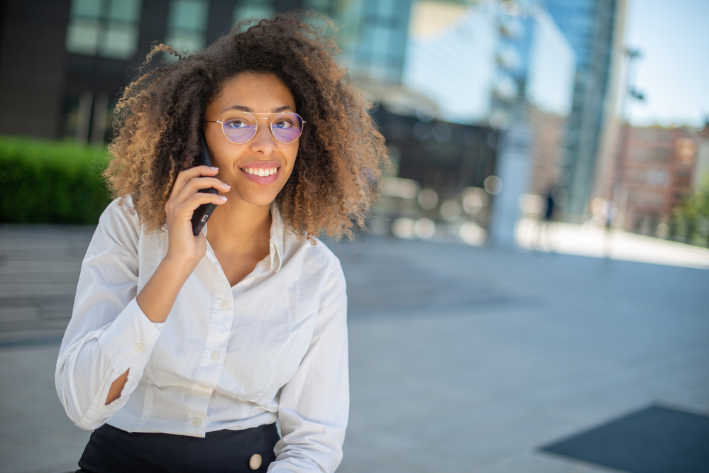 A cute black girl with curly hair follicles uses a natural hair cleanser to encourage hair growth.