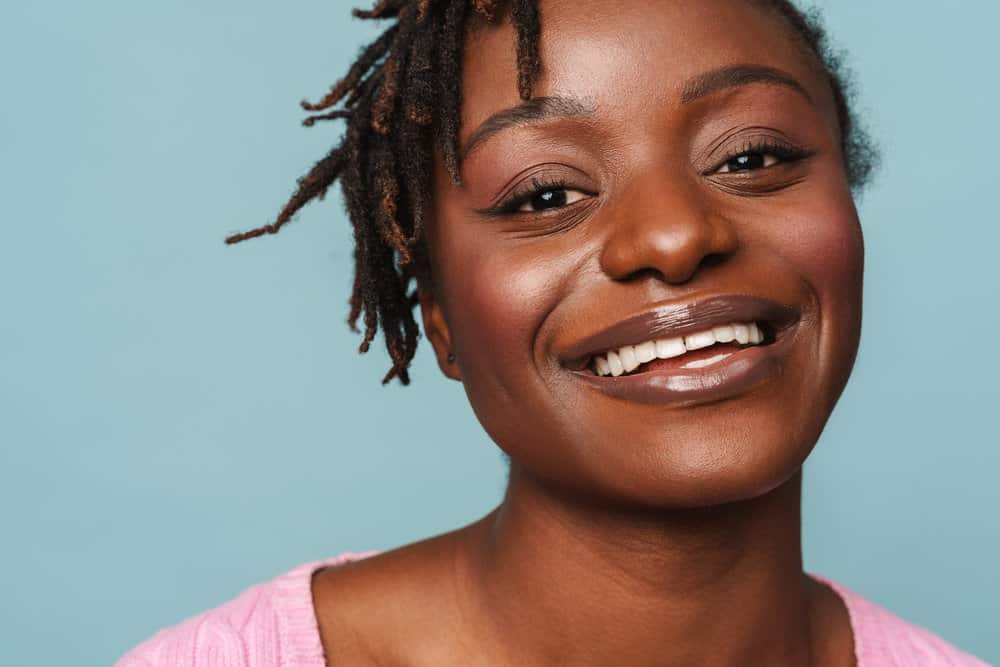 A black female with 4B natural hair wearing her healthy hair in braid locs styled with a palm rolling technique.