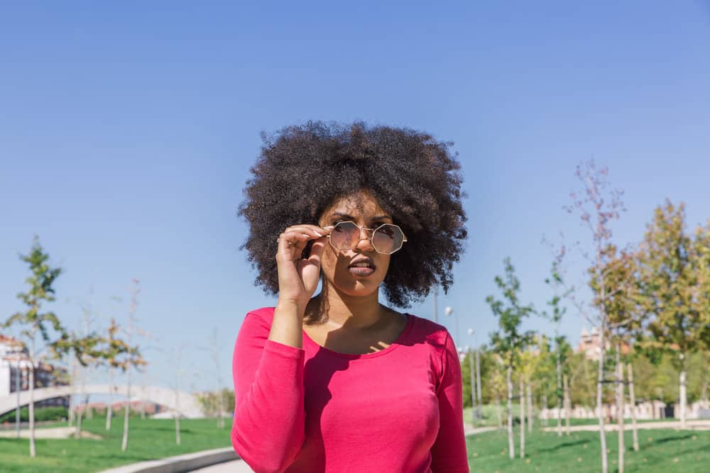 A very pretty brown-skin girl with a 4A hair type wearing a fringe-forward DIY trim.