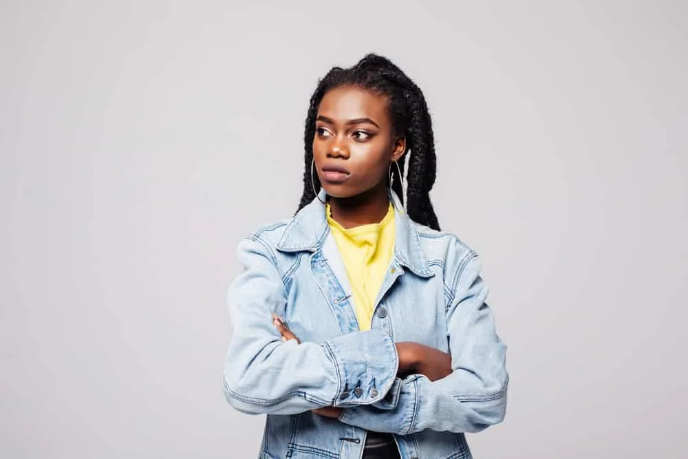 A young black female is wearing multiple braids created with a classic French braid technique.