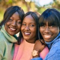 Three African American friends wearing human hair lace wigs with and without bangs covering their forehead.