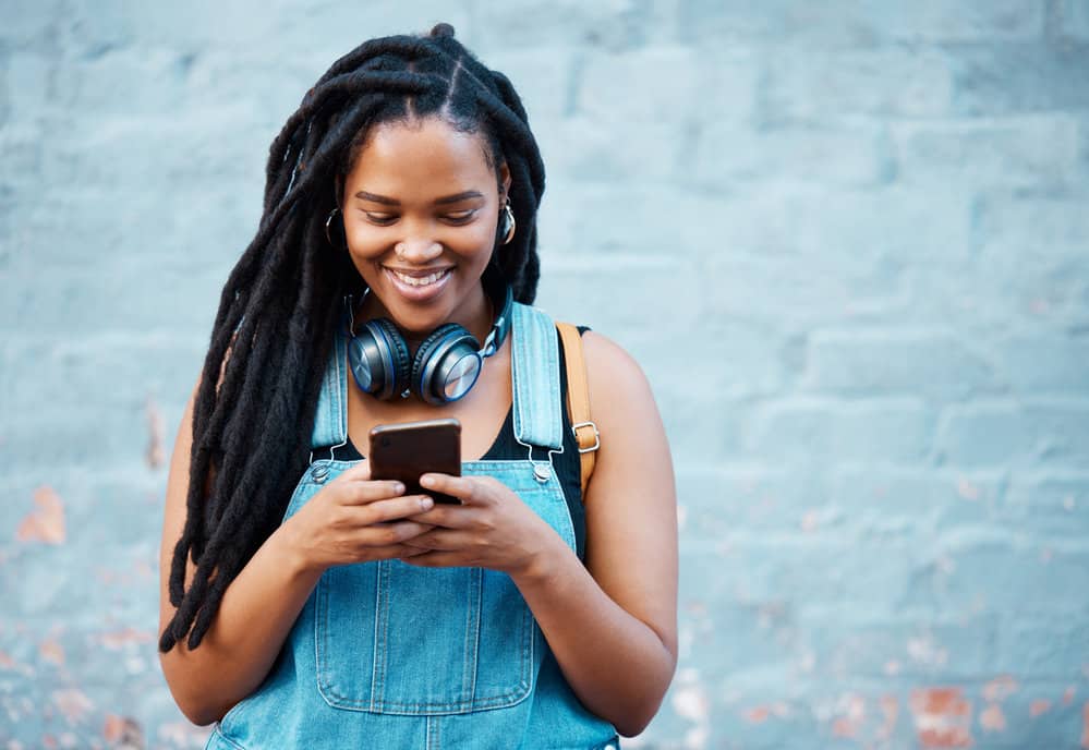 A black woman reading about how to fix loose natural hair strands when maintaining locs.