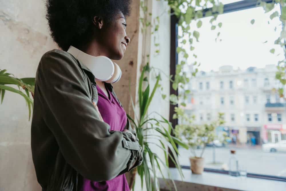 A beautiful young black woman uses jojoba oil within her hair regimen to encourage natural hair growth.