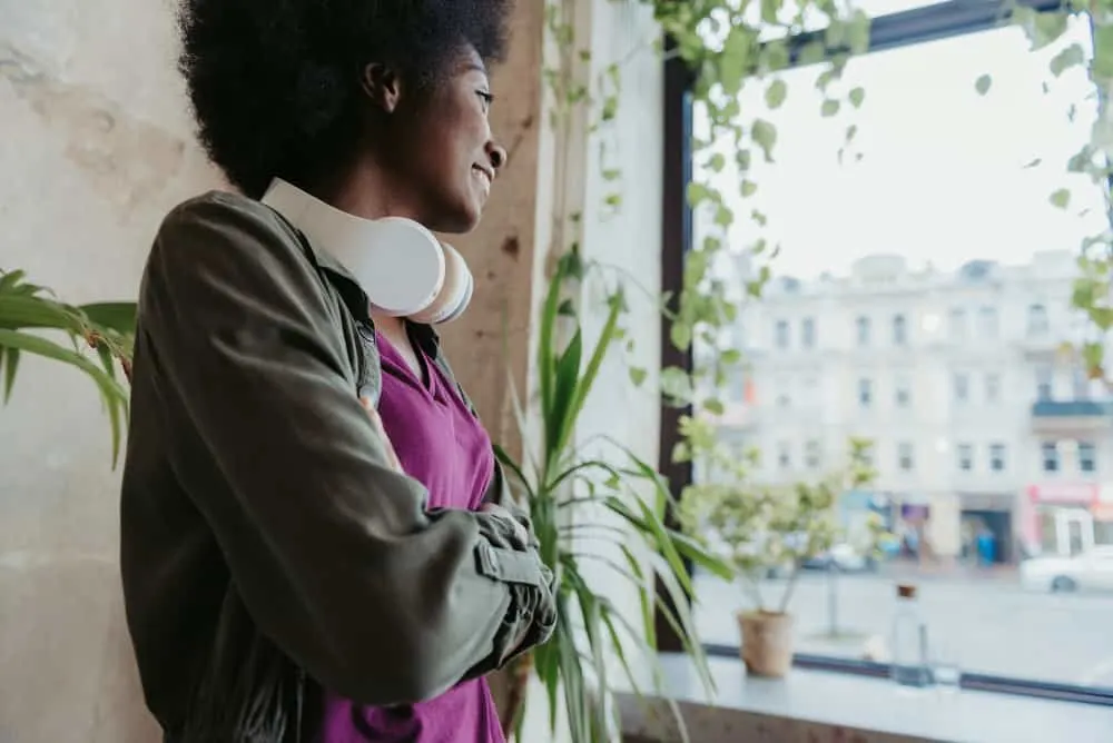 How to Grow 4C Hair Quickly: Longer, Faster, and Naturally 5 A beautiful young black woman uses jojoba oil within her hair regimen to encourage natural hair growth.