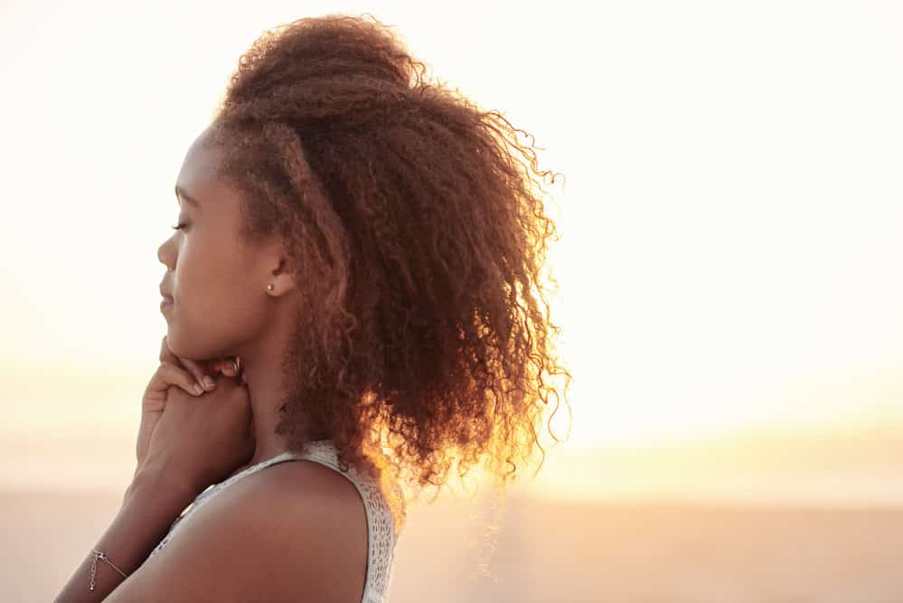 A stylish black girl let her wet hair air dry after spending a day at the beach.