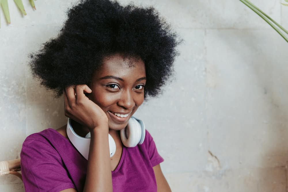 A female with a curly afro has been stretching natural hair with the banding method to reduce hair shrinkage.