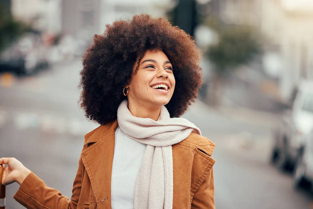 A beautiful black woman with curly hair follicles styled with pure aloe vera gel and flaxseed oil.