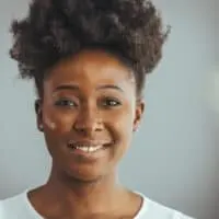 A black woman with 4C natural hair strands styled with a leave-in conditioner to retain moisture.