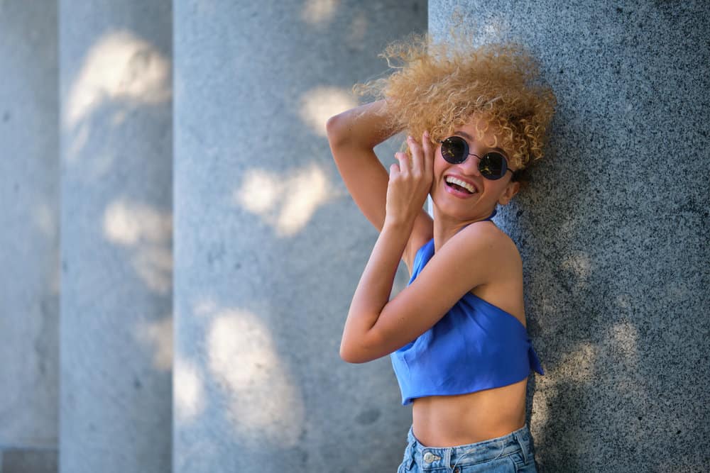 A young woman with healthier hair strands wondering if you should use olaplex on damp or dry hair.