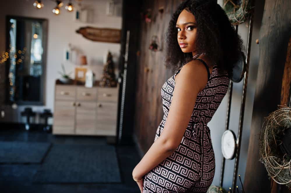 An African American female is wearing a super soft, stylish wig installed by a celebrity stylist.