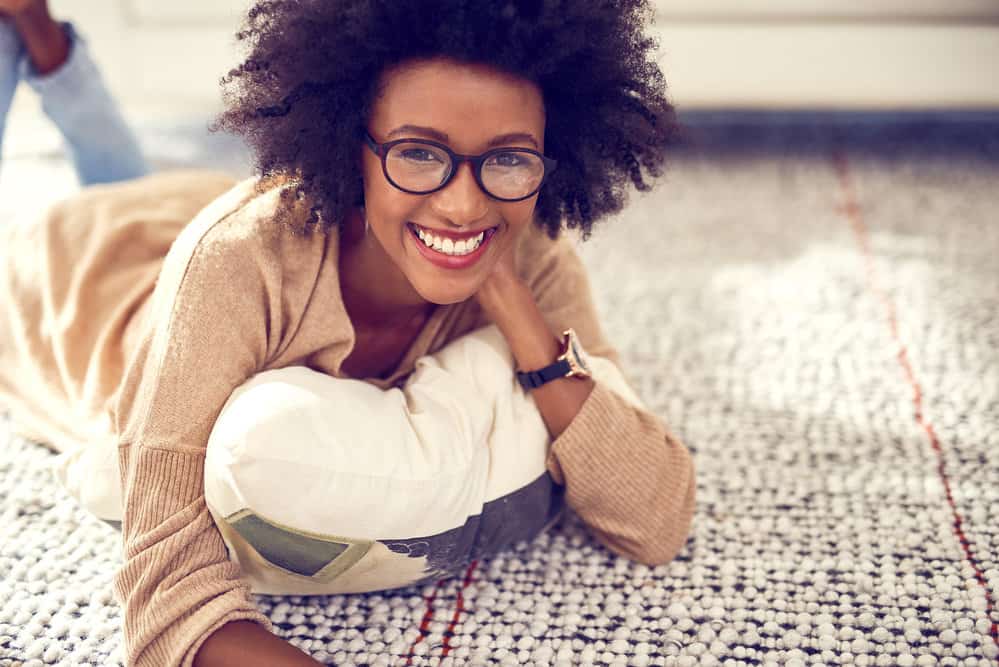 A young female dried her damp hair with a T-shirt creating frizz on her naturally curly locks.