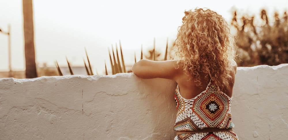 A back view of a female's creamy blonde hair with orange tones and unwanted warmth.