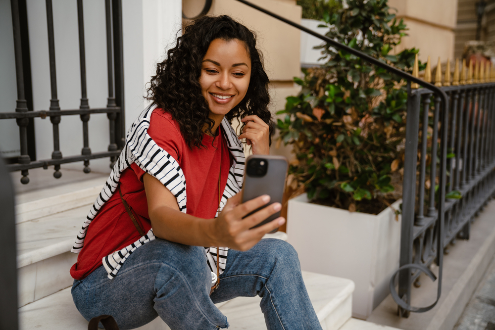 This beautiful black woman with fine hair showcases her defined curls and prevents hair loss by avoiding tight hairstyles and using protective methods to wash curly hair strands.