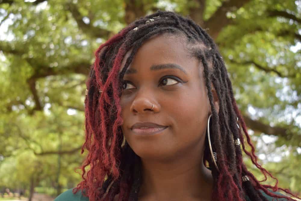 With her mid-length butterfly locs, she achieves a stylish and versatile protective style that complements her natural hair texture with thinner locs.