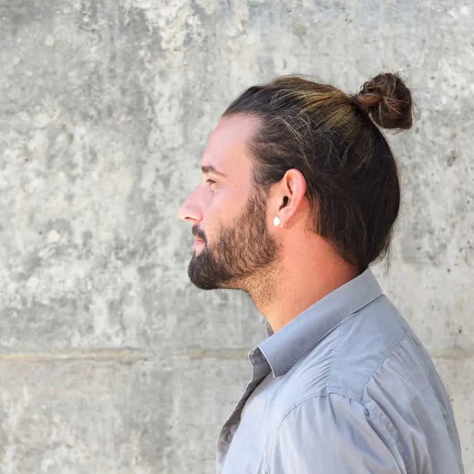 He embraces his thin hair by using the man bun as a stylish and effective way to create volume and fullness.