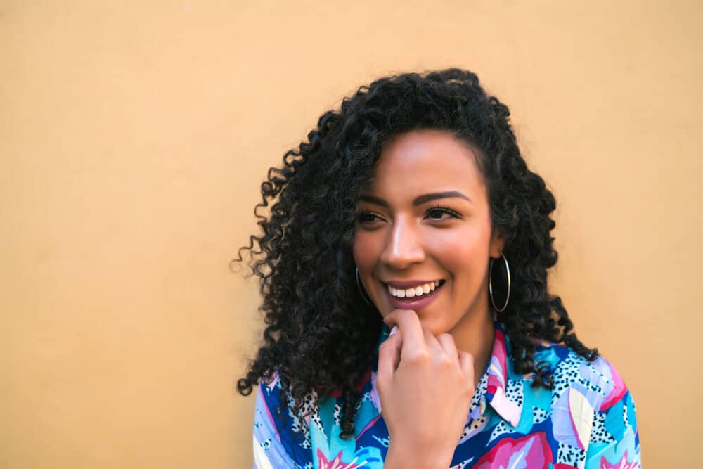 How to Curl Hair for Beginners: How to Put Curls in Your Hair 8 She expertly handles her own hair, skillfully maneuvering the curling wand to create beautiful waves that cascade throughout her entire head.