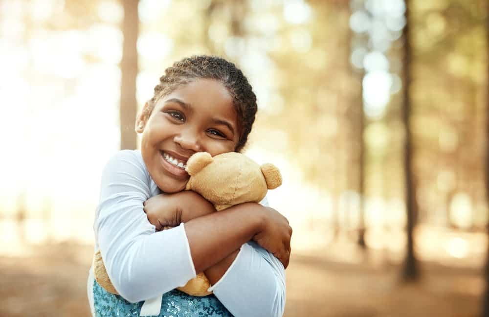 Colorful accessories, like beads and colored threads, adorn kids braids, adding a playful touch to her kid's box braids.