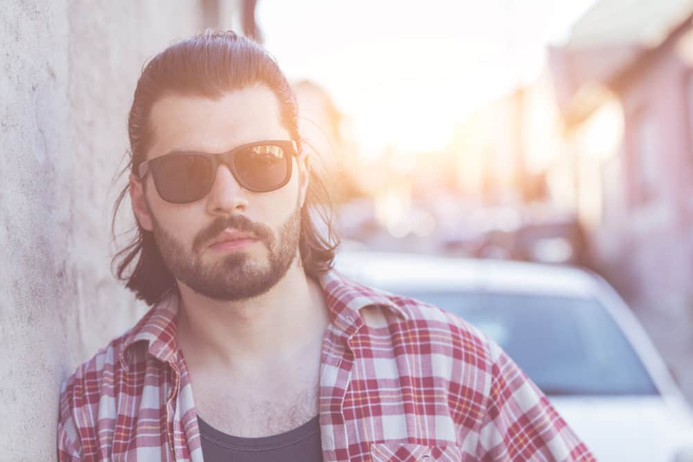 To maintain his desired look, he uses a touch of hair spray to add extra hold and volume to his curly mullet.