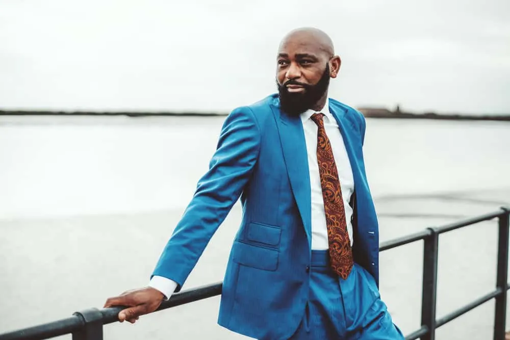 Despite his thinning hair and balding crown, the handsome African man rocks a skin fade hairstyle that accentuates his strong features.