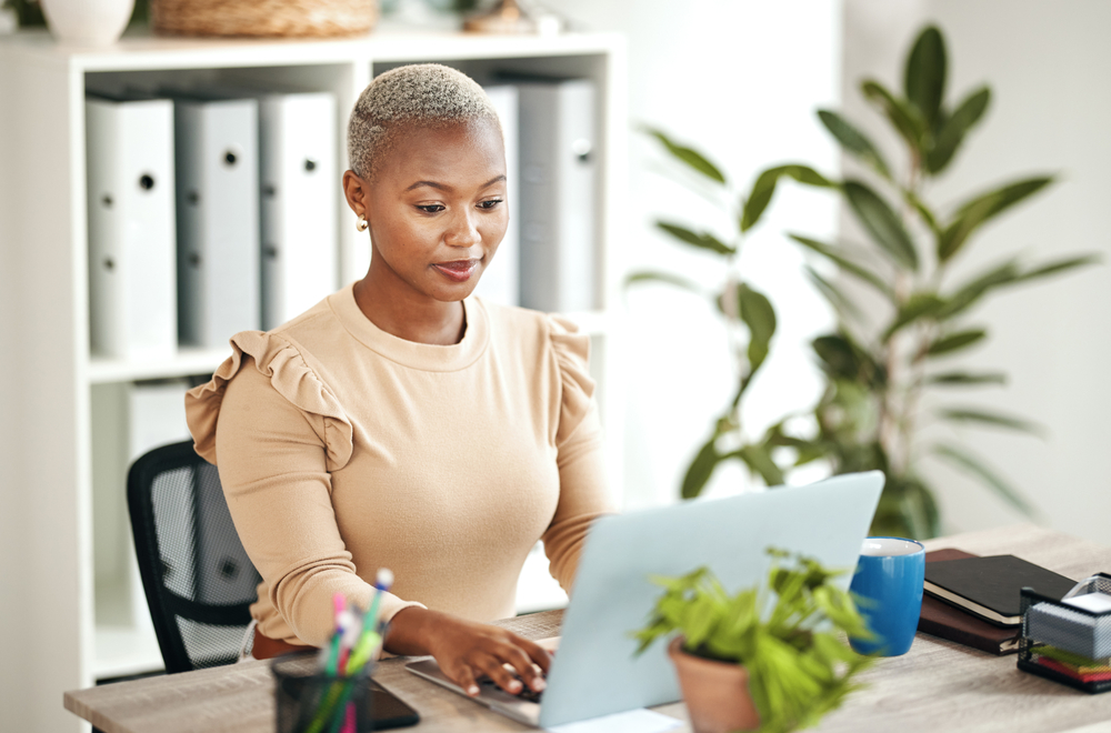 Rocking a beautiful hair color transformation, the African American woman dons a lighter shade that seamlessly blends with her natural roots for a flawless look.