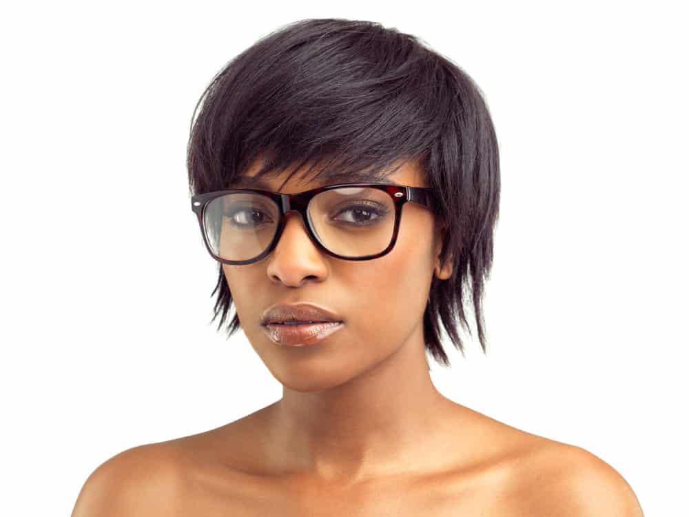 A beautiful African woman wearing one of our favorite bob haircuts created with a one-inch curling iron and texturizing spray.