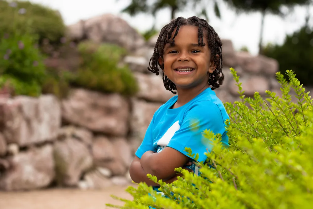 Sporting short hair braids, the toddler's braided locks and natural twist hairstyle highlight his individuality and showcase his unique curl pattern.
