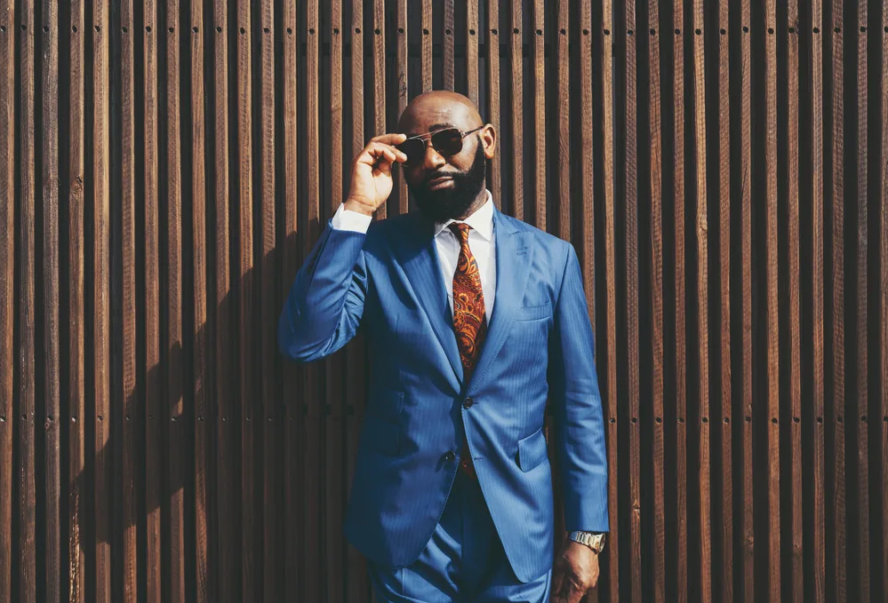 Haircuts for Balding Men: Best Balding Haircuts and Styles 7 The gentleman's natural hair texture and thick, dark brown facial hair complement his bald head, exuding a confident and masculine style.