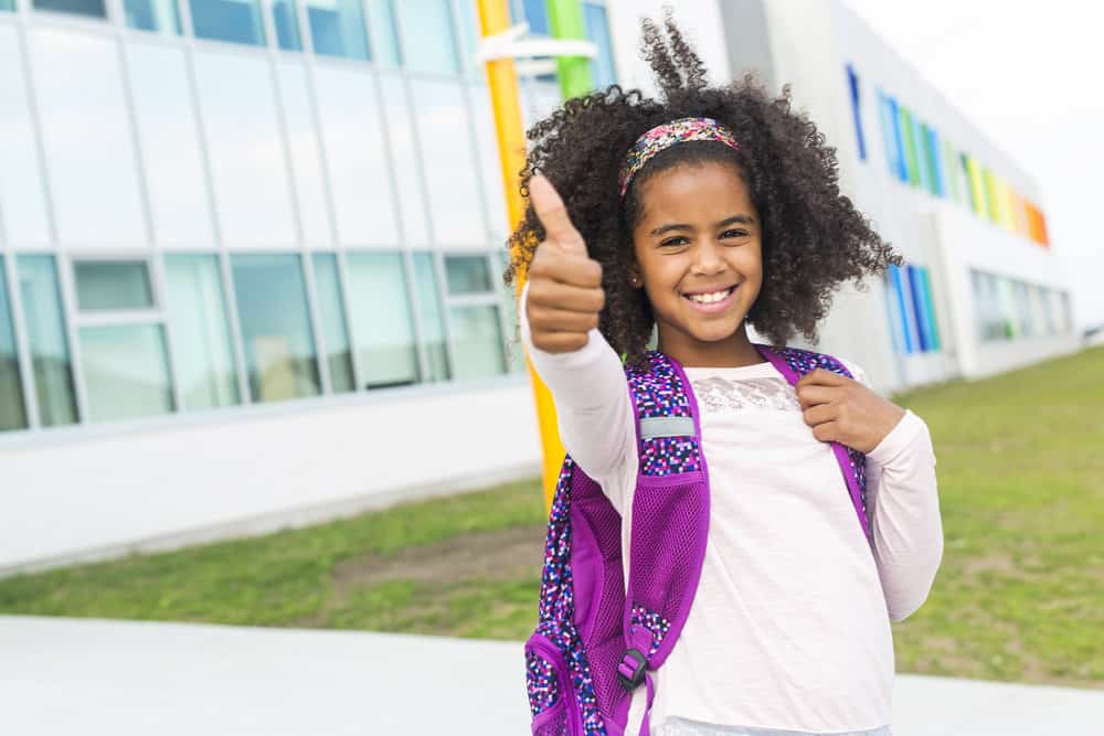 The black toddler's simple bun with curly ends is one of our favorite braided hairstyles for little girls that is low-maintenance yet adorable allowing her to play and explore with ease.