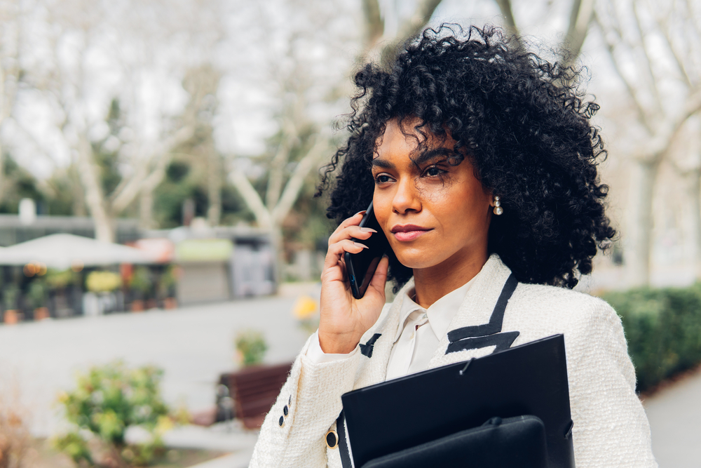 The fashionable black businesswoman proudly embraces her naturally curly hair, using a curly hair shampoo and curl cream to define her beautiful curls.