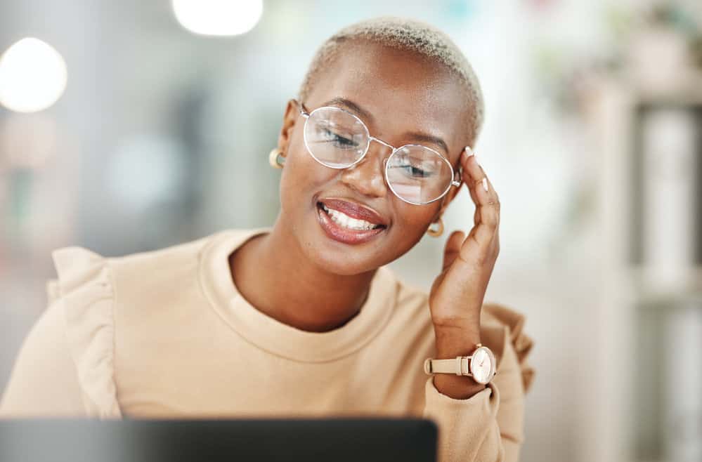 The cute woman confidently showcases her style, flaunting a stunning hair transformation with dark brown skin and a luscious bright blonde hue.