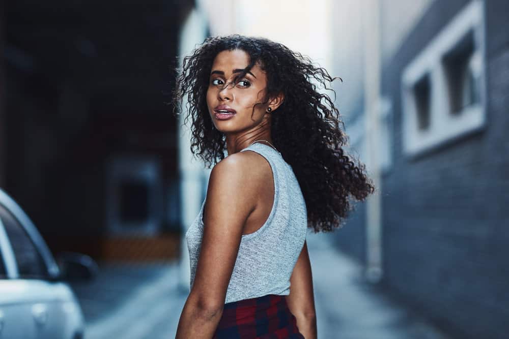 Her beautiful curly hair, once full of life and bounce, now battles frizz due to the heat styling with a blow dryer and frizz-control gel.