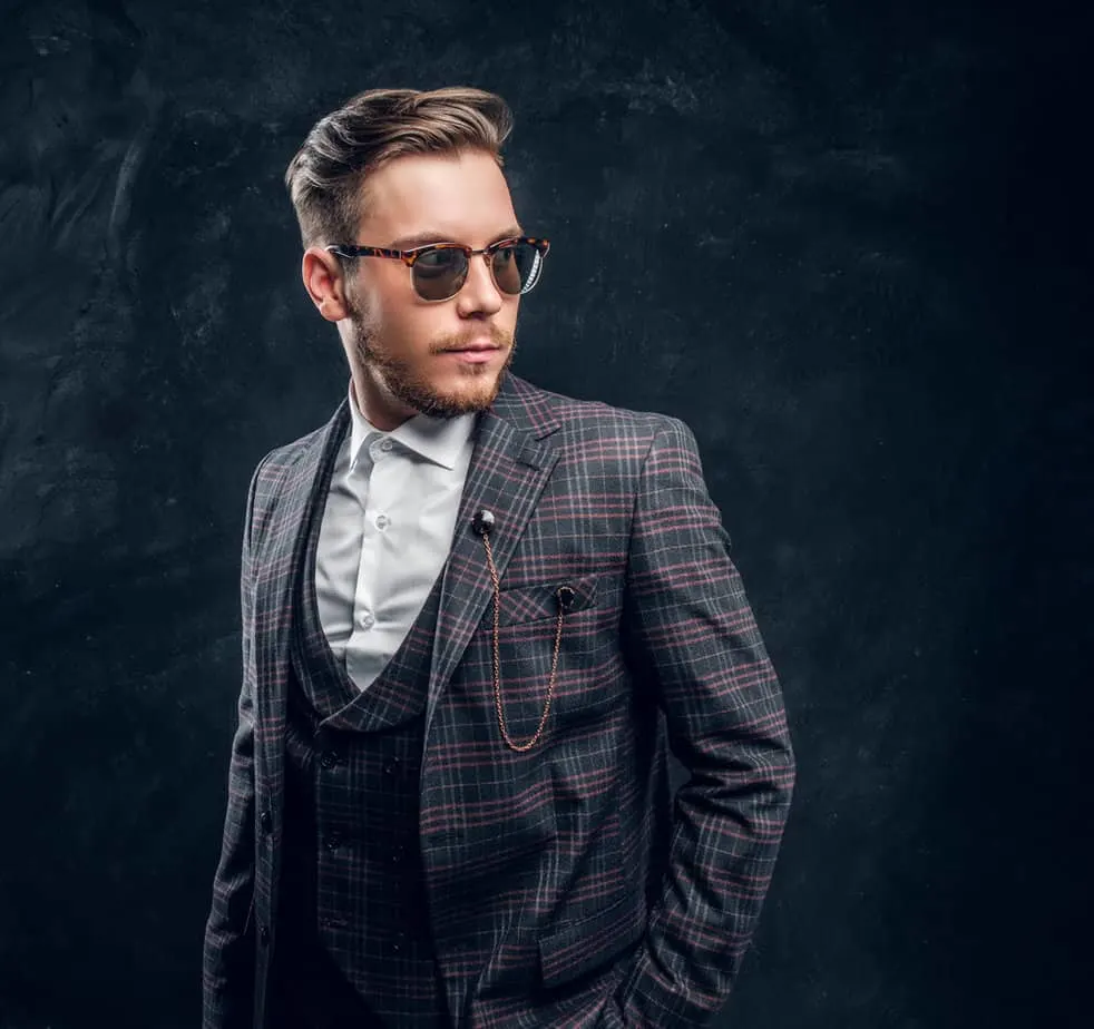 Peaky Blinders Haircut: How to Do Peaky Blinders Haircuts 12 The young man pays homage to the iconic Paul Anderson with his hairstyle, featuring a messy ivy league haircut and a full, well-groomed lumberjack beard.