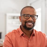 A mature black man that works in the hair restoration industry is using Bosley hair products to regrow hair strands after experiencing thinning hair over the last two years.