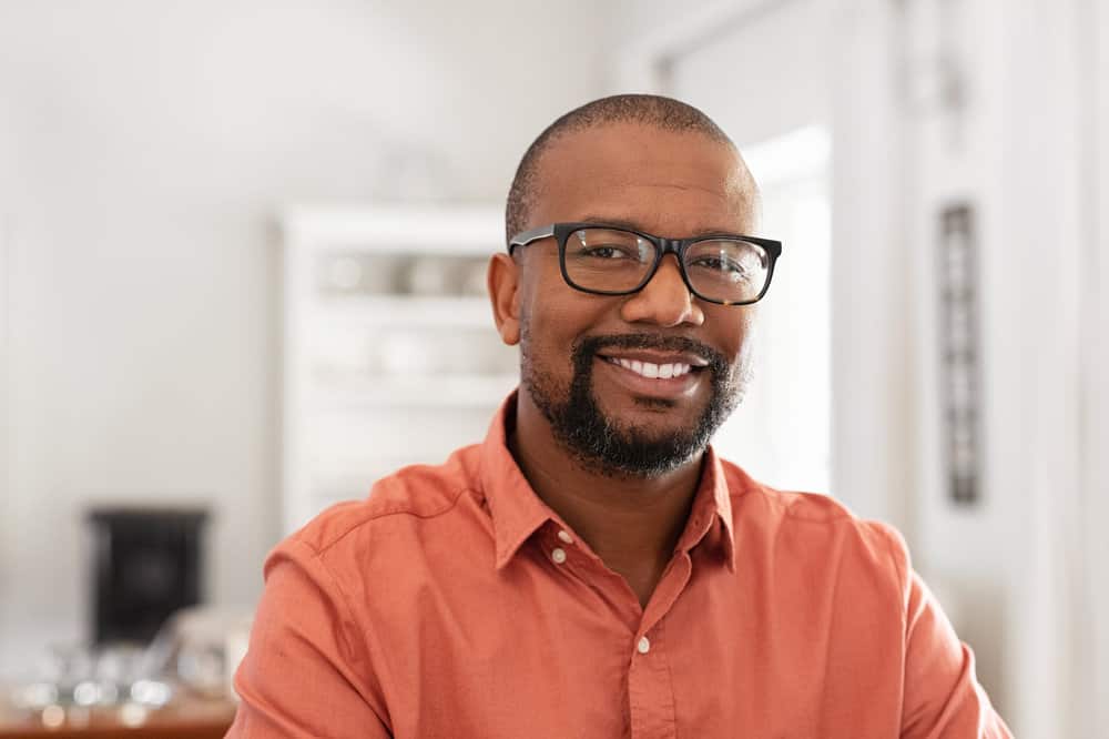 A mature black man that works in the hair restoration industry is using Bosley hair products to regrow hair strands after experiencing thinning hair over the last two years.
