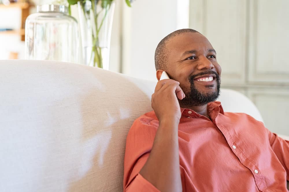 A guy talking on the phone about how hair regrowth can be achieved through the Bosley procedure, a hair transplantation procedure using donor hair follicles.