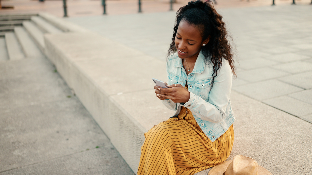 This black woman's French braids and strategically placed bobby pins aid in creating heatless curls, promoting hair health and minimizing damage.