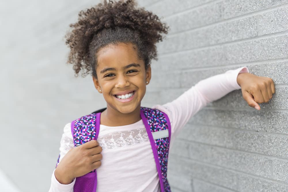 With her hair styled in a simple bun with curly ends, the black kids joy and innocence is clear as she's embracing her natural curls.