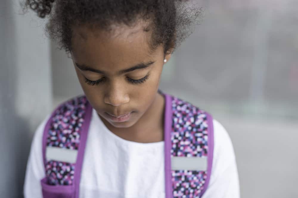 The young black girls simple bun with curly ends is a timeless and stylish choice, highlighting her long hair and showcasing her beauty with creative hairstyles.