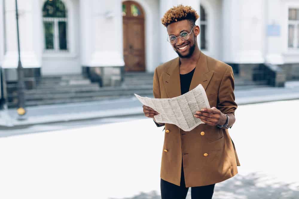 The young man rocks a trendy look with blonde hair dye covering the tips of his black hair, adding a touch of edginess with bleached tips.