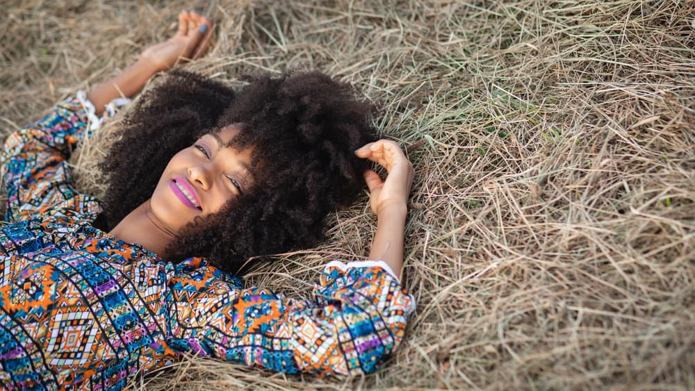 The black woman understands the importance of a patch test before applying neem oil directly to her scalp, especially for sensitive skin.