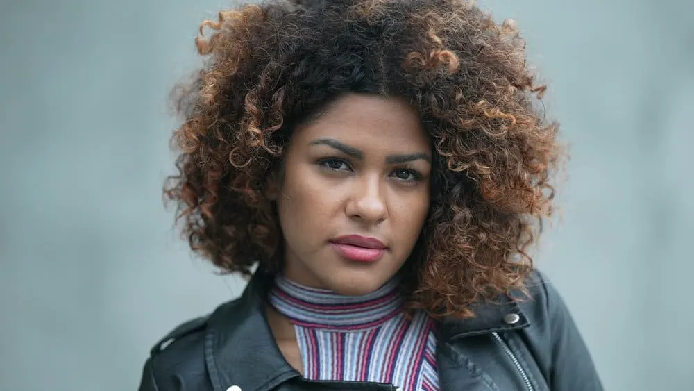 What Color Should I Dye My Hair? How to Choose a Hair Color 14 The stunning black female with light skin showcases her hair history and hair coloring, transformed with warm shades of red and brown for a unique and beautiful look.
